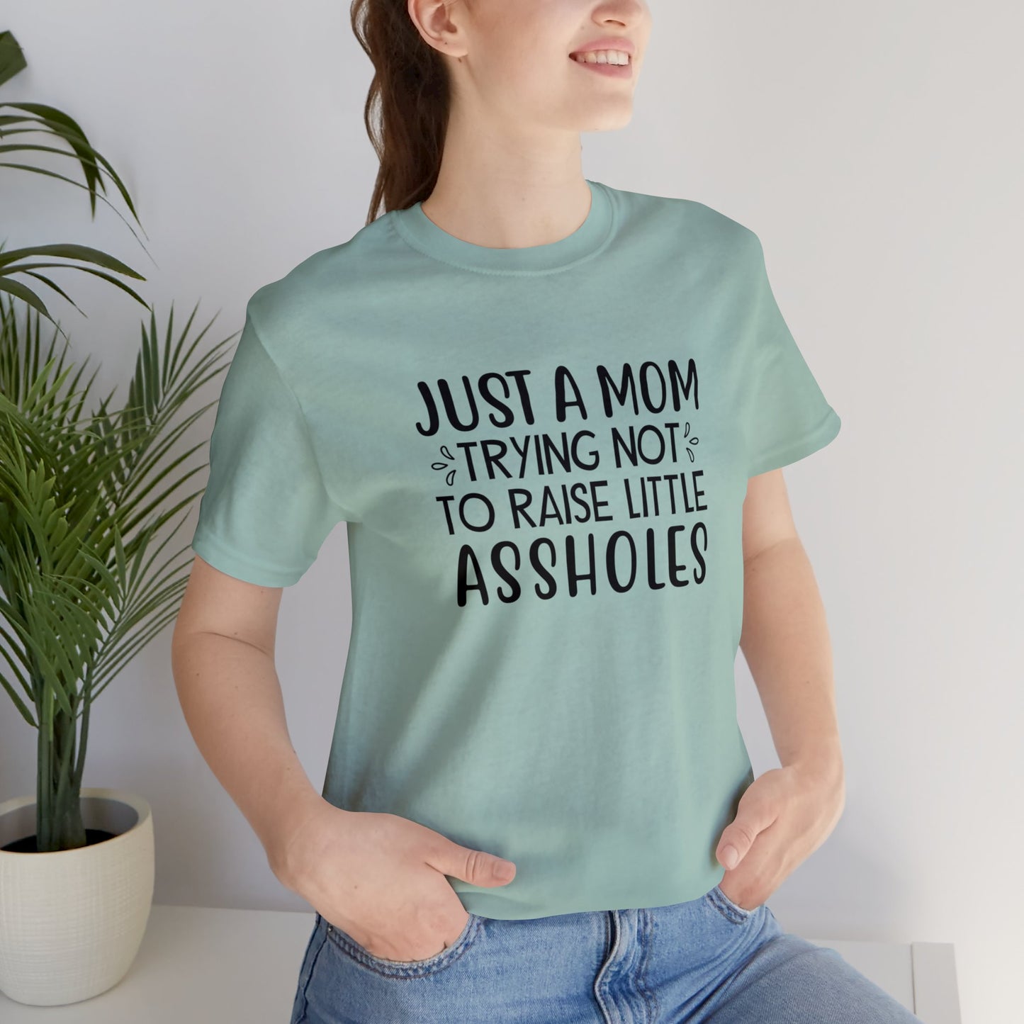 Just a mom trying not to raise little assholes Unisex Jersey Short Sleeve Tee