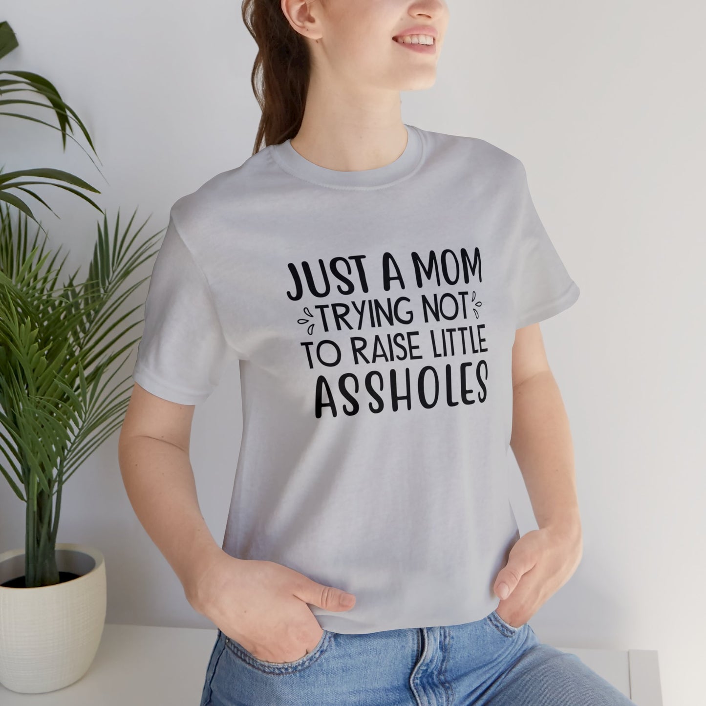 Just a mom trying not to raise little assholes Unisex Jersey Short Sleeve Tee