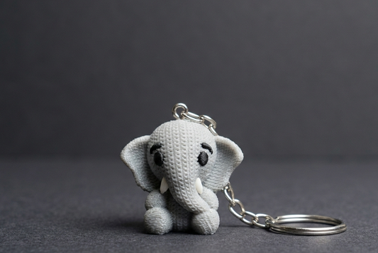 Gray elephant keychain on a dark background