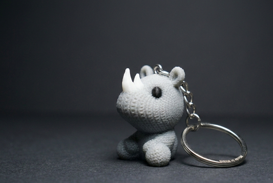 White rhinoceros keychain on a dark gray background
